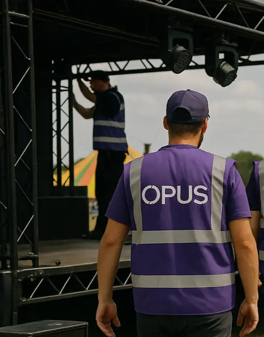 Opus AV crew member working under purple stage lighting