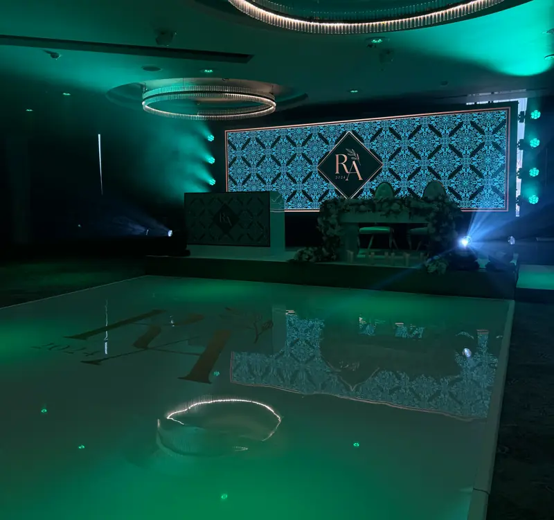 Green lighting and a patterned LED backdrop in a wedding room